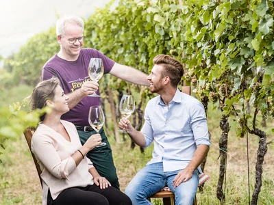 Ihr Hotel in Tramin: ein Genussort inmitten der Weinberge Drei Personen beim Weintrinken in einem Weinberg
