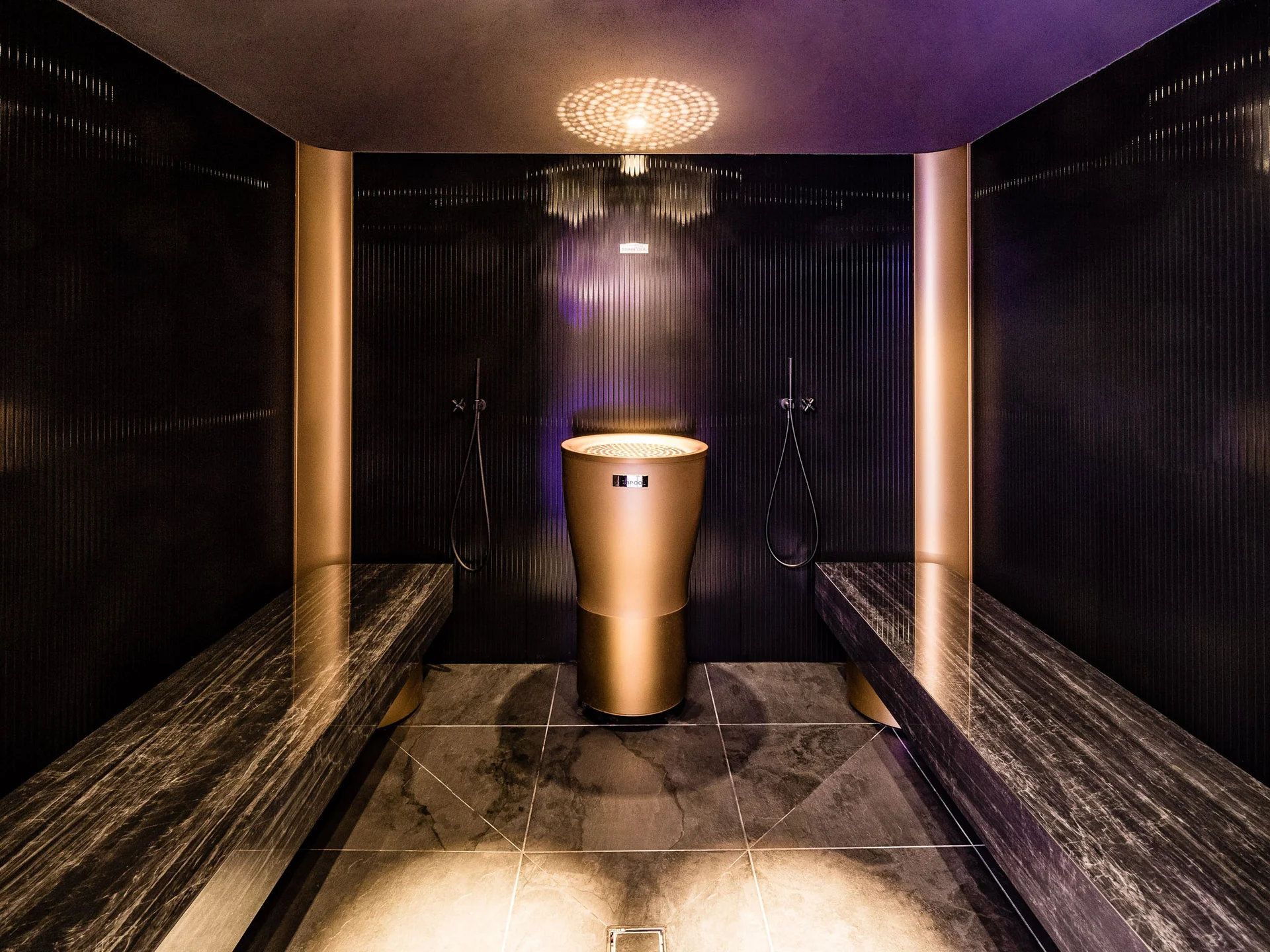 Ihr Hotel in Tramin: ein Genussort inmitten der Weinberge Moderner Dampfbadraum mit goldfarbenem Dampfgenerator und Sitzbänken aus Marmor